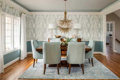 Mid-sized elegant medium tone wood floor, brown floor and wallpaper dining room photo in Other with blue walls