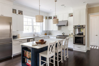 Inspiration for a mid-sized traditional l-shaped eat-in kitchen in New York with an undermount sink, recessed-panel cabinets, white cabinets, marble benchtops, white splashback, subway tile splashback, stainless steel appliances, dark hardwood floors and with island.