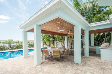 Inspiration for a large contemporary backyard stone patio kitchen remodel in Tampa with a gazebo