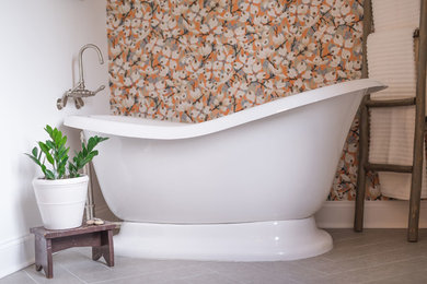 Example of a large tuscan master gray tile and ceramic tile porcelain tile and gray floor freestanding bathtub design in New York with a two-piece toilet, white walls, an undermount sink, marble countertops, a hinged shower door and gray countertops