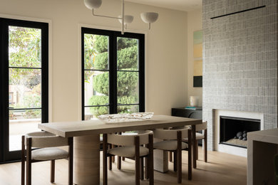 Minimalist light wood floor dining room photo in Orange County with a tile fireplace
