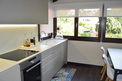 Foto de cocina comedor lineal rústica grande sin isla con fregadero bajoencimera, armarios con paneles lisos, puertas de armario grises, salpicadero beige, electrodomésticos de acero inoxidable, suelo marrón y suelo de madera oscura