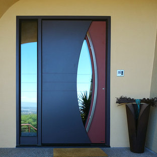 Photo of a mid-sized eclectic front door in San Francisco with yellow walls, concrete floors, a single front door, a metal front door and grey floor.