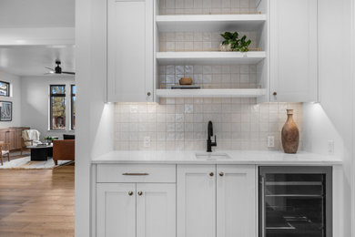 Inspiration for a timeless home bar remodel in Other with recessed-panel cabinets, white cabinets and white backsplash