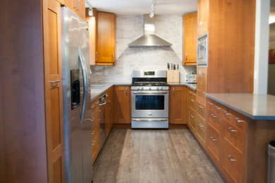 Open concept kitchen - mid-sized transitional u-shaped medium tone wood floor open concept kitchen idea in Vancouver with an undermount sink, shaker cabinets, medium tone wood cabinets, quartzite countertops, white backsplash, ceramic backsplash, stainless steel appliances and no island