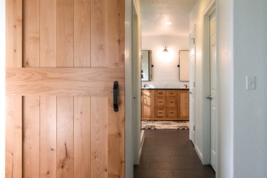 Mid-sized country master white tile and ceramic tile porcelain tile and black floor double shower photo in Other with shaker cabinets, medium tone wood cabinets, a one-piece toilet, white walls, a drop-in sink and granite countertops