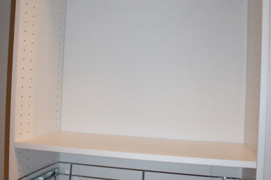 Example of a small classic gender-neutral light wood floor and brown floor walk-in closet design in New York