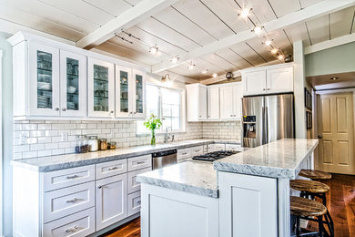 Mid-sized arts and crafts l-shaped open plan kitchen in San Diego with an undermount sink, shaker cabinets, white cabinets, granite benchtops, white splashback, subway tile splashback, stainless steel appliances, dark hardwood floors, with island and brown floor.
