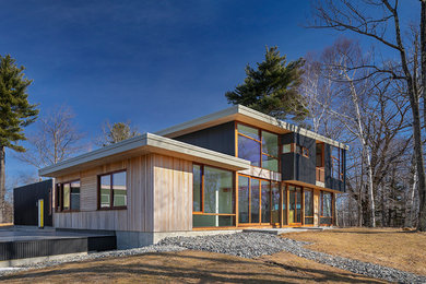 Expansive modern two-storey house exterior in Boston with mixed siding and a flat roof.