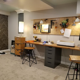 Photo of a medium sized industrial fully buried basement in Chicago with grey walls, carpet, a standard fireplace, a plastered fireplace surround and grey floors.