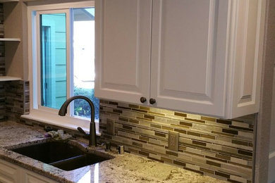 Mid-sized transitional kitchen photo in San Francisco with a double-bowl sink, raised-panel cabinets, white cabinets, marble countertops, brown backsplash, matchstick tile backsplash and stainless steel appliances