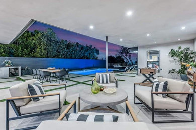 Inspiration for a mid-sized 1950s backyard concrete paver patio remodel in Los Angeles with a bbq area and a roof extension