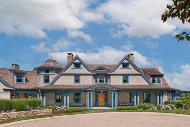 Coastal beige three-story wood and shingle exterior home idea in New York with a shingle roof and a brown roof