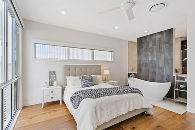 Inspiration for a large modern master bedroom in Brisbane with white walls, medium hardwood floors and beige floor.