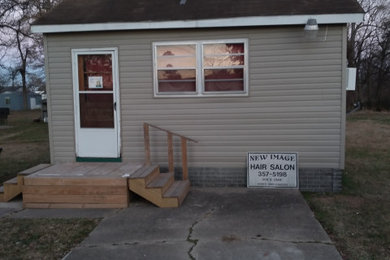 Mid-sized beige one-story vinyl and board and batten exterior home photo in Other with a shingle roof and a black roof