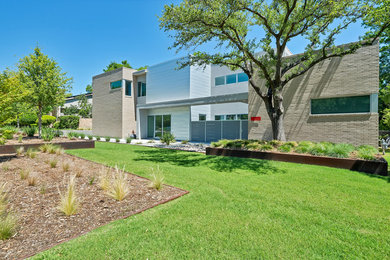 Photo of an expansive modern two-storey multi-coloured house exterior in Dallas with mixed siding and a flat roof.