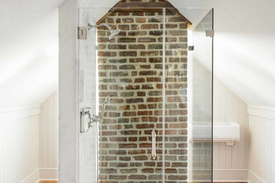 Mid-sized urban master medium tone wood floor and brown floor alcove shower photo in Charleston with open cabinets, white walls, a wall-mount sink, a hinged shower door, gray cabinets and marble countertops