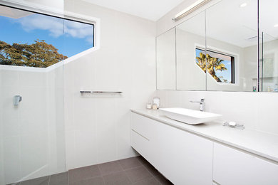 Mid-sized modern master bathroom in Sydney with flat-panel cabinets, white cabinets, an open shower, white tile, grey walls, ceramic floors, a vessel sink and solid surface benchtops.