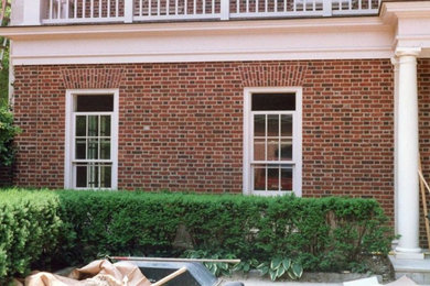 Imagen de fachada marrón de dos plantas con revestimiento de ladrillo