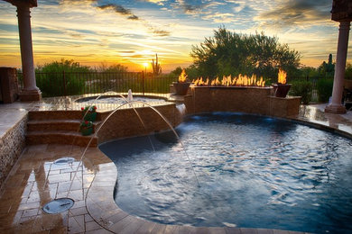 Mid-sized contemporary backyard custom-shaped natural pool in Houston with a water feature and natural stone pavers.