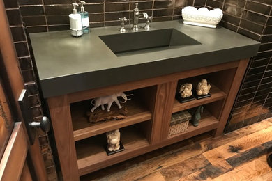 Inspiration for a modern medium tone wood floor and multicolored floor powder room remodel in Phoenix with open cabinets, brown cabinets and concrete countertops