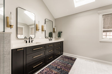 Modern inredning av ett stort en-suite badrum, med svarta skåp, ett fristående badkar och granitbänkskiva