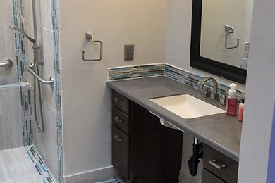 Alcove shower - mid-sized transitional kids' beige tile, blue tile, brown tile, gray tile and ceramic tile porcelain tile alcove shower idea in Phoenix with flat-panel cabinets, black cabinets, a one-piece toilet, gray walls, an undermount sink and solid surface countertops