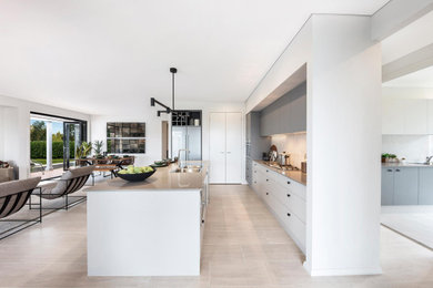 Design ideas for a large contemporary open plan kitchen in Wollongong with a double-bowl sink, shaker cabinets, grey cabinets, quartz benchtops, grey splashback, ceramic splashback, stainless steel appliances, cement tiles, with island, grey floor and grey benchtop.