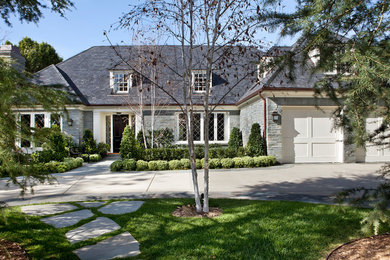 Inspiration for a large traditional two-storey grey house exterior in Los Angeles with stone veneer, a gable roof and a tile roof.
