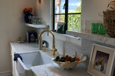 Example of a small tuscan galley terra-cotta tile and red floor enclosed kitchen design in Santa Barbara with a farmhouse sink, shaker cabinets, white cabinets, marble countertops, white backsplash, marble backsplash, stainless steel appliances, no island and white countertops