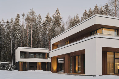На фото: большой, двухэтажный, белый дом в современном стиле с комбинированной облицовкой, плоской крышей, крышей из смешанных материалов, черной крышей и отделкой планкеном с