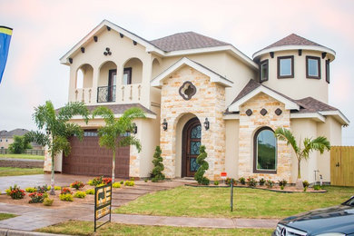 Inspiration for a large timeless beige two-story mixed siding exterior home remodel in Other with a shingle roof
