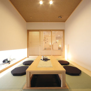 Exemple d'une salle à manger asiatique fermée avec un mur blanc, un sol de tatami et un sol vert.
