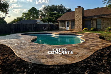 Inspiration for a mid-sized backyard stamped concrete and custom-shaped pool remodel in Dallas