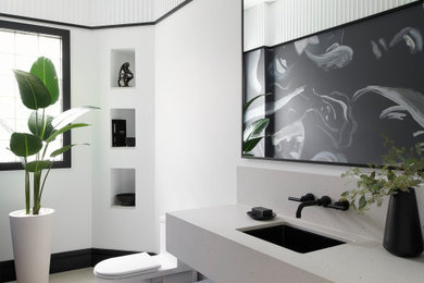 Inspiration for a large contemporary powder room in Toronto with flat-panel cabinets, a one-piece toilet, white walls, an integrated sink, engineered quartz benchtops, beige floor, white benchtops, a floating vanity and wallpaper.
