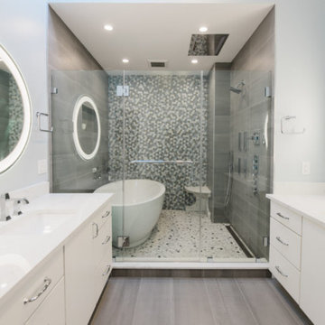 Bath Sanctuary: Freestanding Tub, Glass Door, White Cabinets, LED Mirror