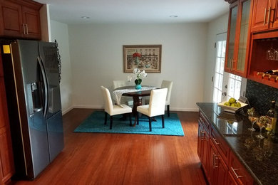Example of a small classic medium tone wood floor and brown floor kitchen/dining room combo design in Seattle with white walls and no fireplace