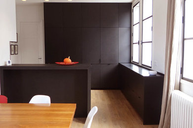 Réalisation d'une grande cuisine design avec parquet clair.