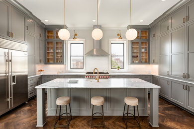 Example of a transitional u-shaped dark wood floor and brown floor kitchen design in Nashville with a farmhouse sink, shaker cabinets, gray cabinets, white backsplash, stainless steel appliances, an island, marble countertops, subway tile backsplash and white countertops