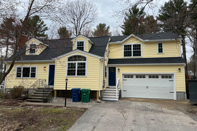 Example of a transitional yellow vinyl house exterior design in Boston with a shingle roof