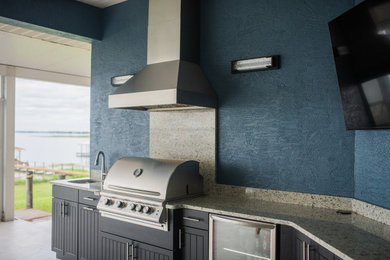 Patio kitchen - contemporary backyard patio kitchen idea in Tampa with a roof extension