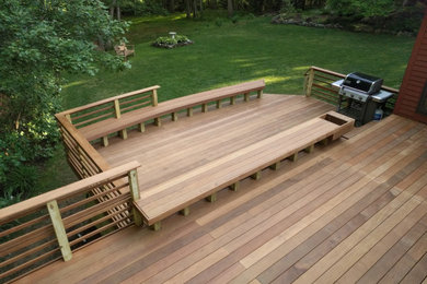 Inspiration for a large modern backyard ground level wood railing deck remodel in Boston