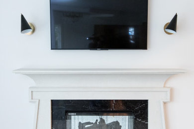 ニューヨークにある広いモダンスタイルのおしゃれなリビング (白い壁、濃色無垢フローリング、標準型暖炉、木材の暖炉まわり、壁掛け型テレビ、茶色い床) の写真