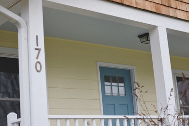 Small farmhouse yellow one-story concrete fiberboard exterior home idea in Other with a shingle roof