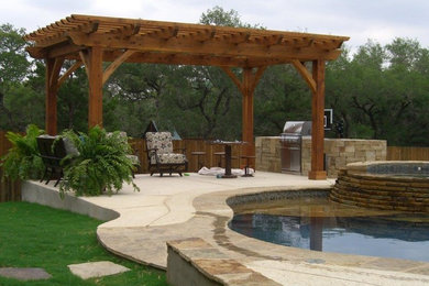 Patio kitchen - large rustic backyard concrete patio kitchen idea in Austin with a pergola