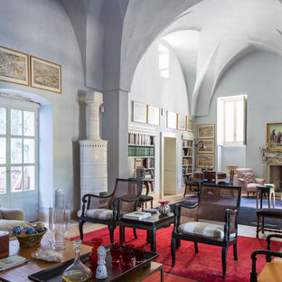 Foto de salón abierto, mediterráneo, extra grande, con paredes azules, chimenea tradicional, marco de chimenea de piedra y suelo beige