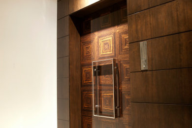 Foto de puerta principal actual grande con paredes blancas, suelo de mármol, puerta simple, puerta de madera oscura, suelo blanco y panelado