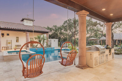 Large elegant backyard tile and custom-shaped pool house photo in Austin