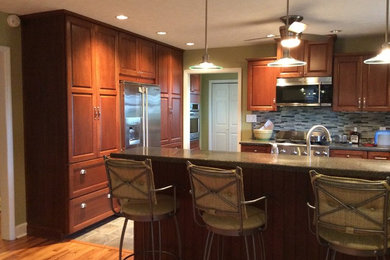 Mid-sized elegant l-shaped porcelain tile open concept kitchen photo in Cincinnati with an undermount sink, shaker cabinets, medium tone wood cabinets, granite countertops, multicolored backsplash, matchstick tile backsplash, stainless steel appliances and a peninsula
