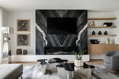 トロントにある広いコンテンポラリースタイルのおしゃれなLDK (白い壁、淡色無垢フローリング、横長型暖炉、石材の暖炉まわり、壁掛け型テレビ) の写真